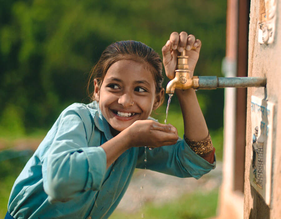 Young girl drinking water from fountain